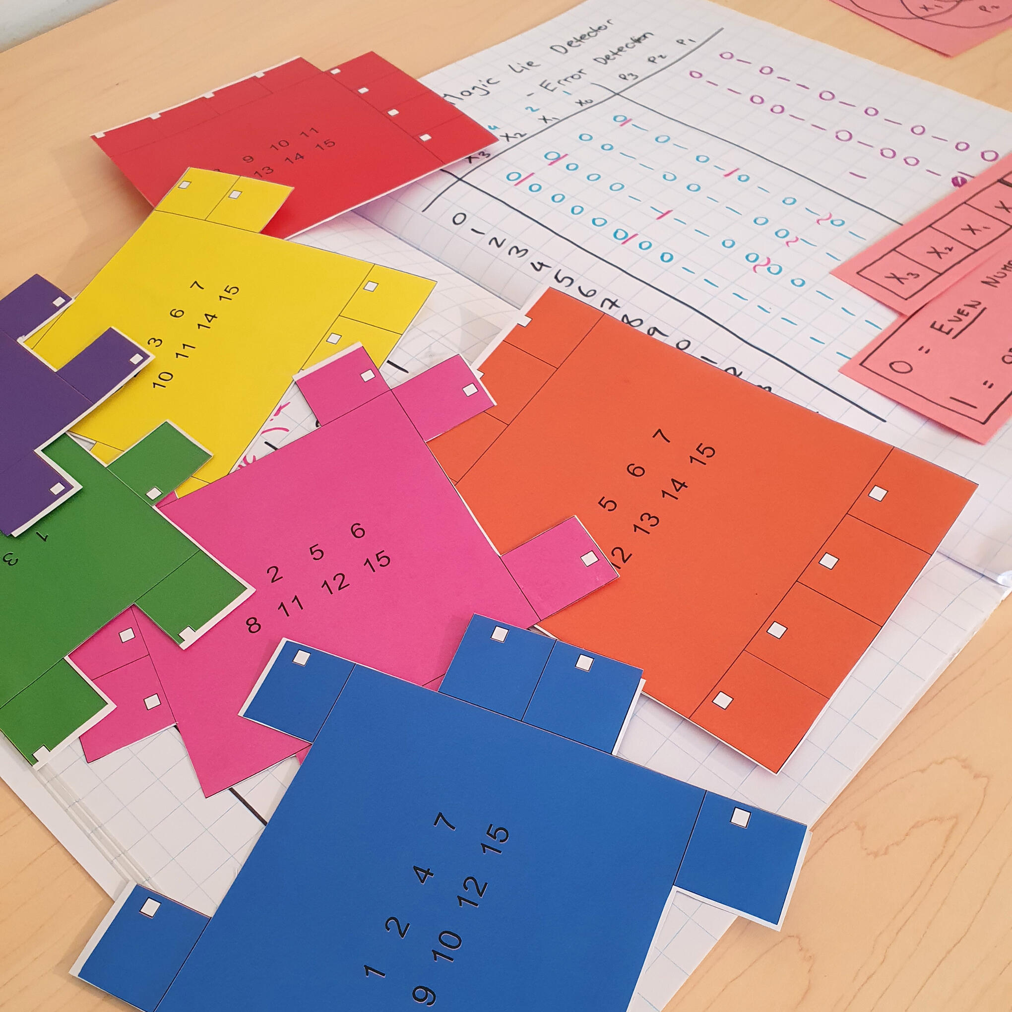 Colourful paper puzzle pieces used in a hands-on Hamming code magic trick, a computer science unplugged (CS unplugged) activity teaching error-correcting codes